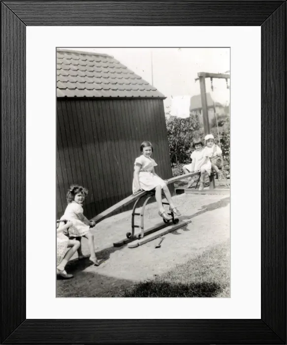 Framed Print : Four young children playing on a see-saw Framed Print : Four young children playing on a see-saw