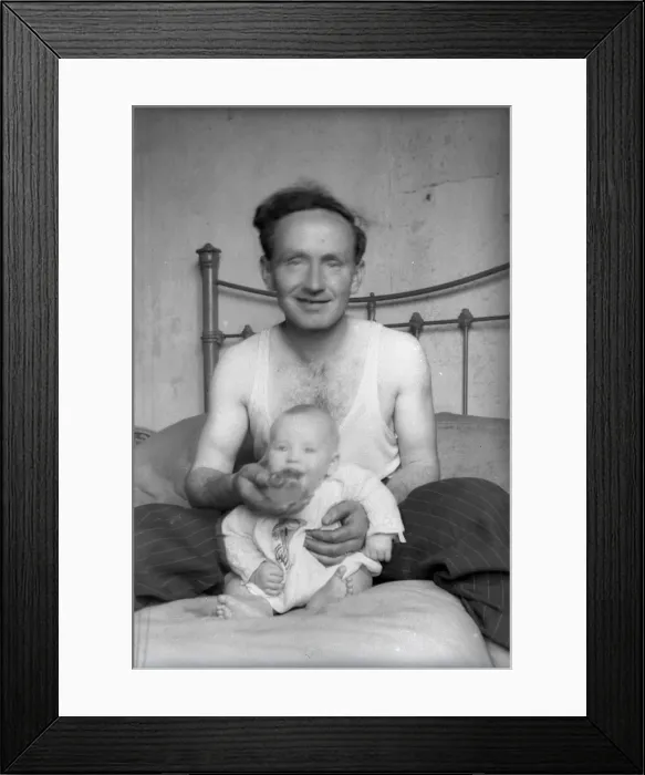Framed Print : Proud Father sitting in bed with his young baby Framed Print : Proud Father sitting in bed with his young baby