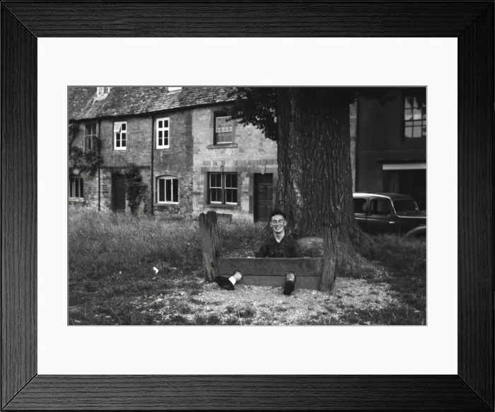 Framed Print : Young man fooling about in The Stocks Framed Print : Young man fooling about in The Stocks