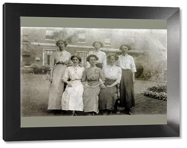 Five women pose for a group photograph in the garden
