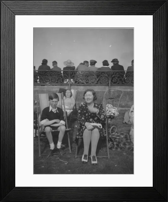 Framed Print : A family on the beach at the seaside, sitting in deckchairs against the sea wall Framed Print : A family on the beach at the seaside, sitting in deckchairs against the sea wall
