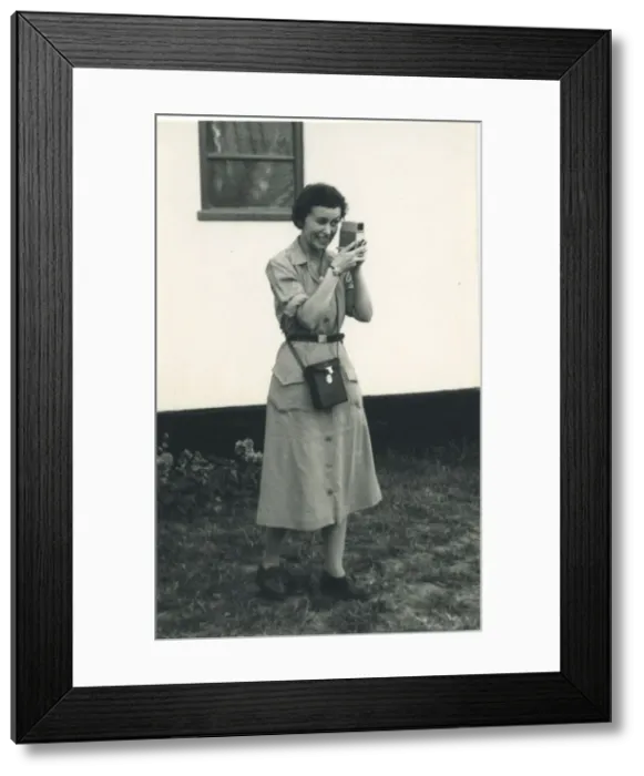 Framed Print : A woman using what looks to be a cine camera, probably a Bell and Howell 252 Framed Print : A woman using what looks to be a cine camera, probably a Bell and Howell 252