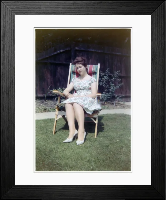 Framed Print : A young lady sat in a neat garden in a canvas-backed chair Framed Print : A young lady sat in a neat garden in a canvas-backed chair