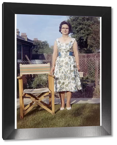 Woman in a neat suburban garden with garden chair