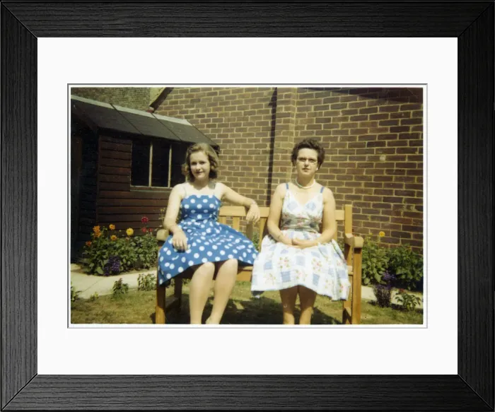 Framed Print : Mother and daughter in summer dresses on a garden bench Framed Print : Mother and daughter in summer dresses on a garden bench