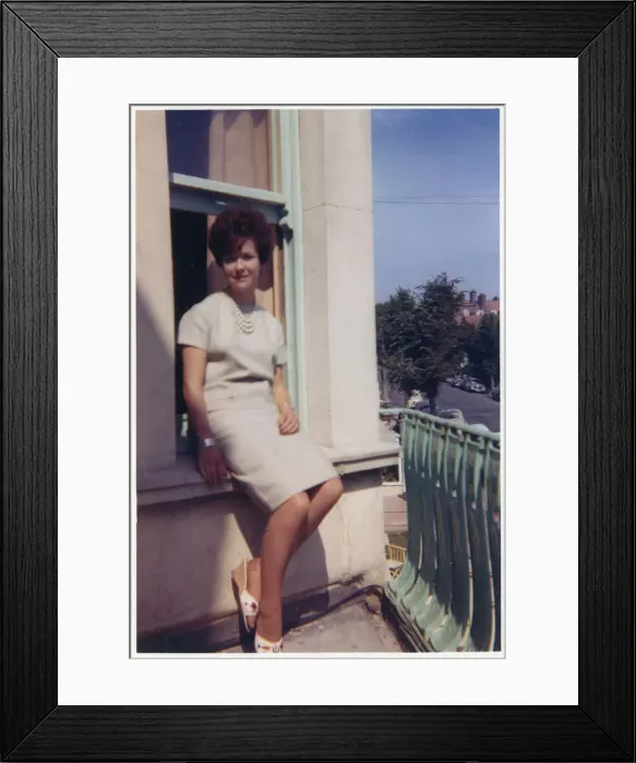 Framed Print : Young lady seated on exterior window ledge - seaside hotel Framed Print : Young lady seated on exterior window ledge - seaside hotel