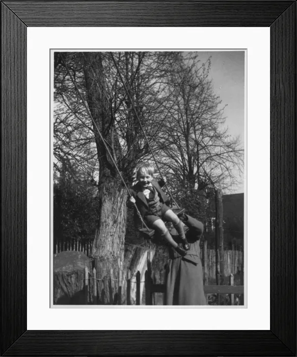 Framed Print : A little boy being pushed on a swing. Date: c. 1950 Framed Print : A little boy being pushed on a swing. Date: c. 1950