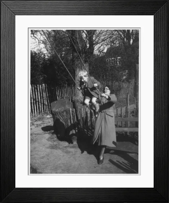 Framed Print : A little boy being pushed on a swing. Date: c. 1950 Framed Print : A little boy being pushed on a swing. Date: c. 1950