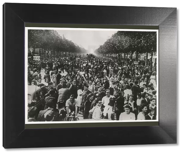 WW2 - An enthusiastic crowd of celebrating Parisians fill the Champs Elysees until dawn