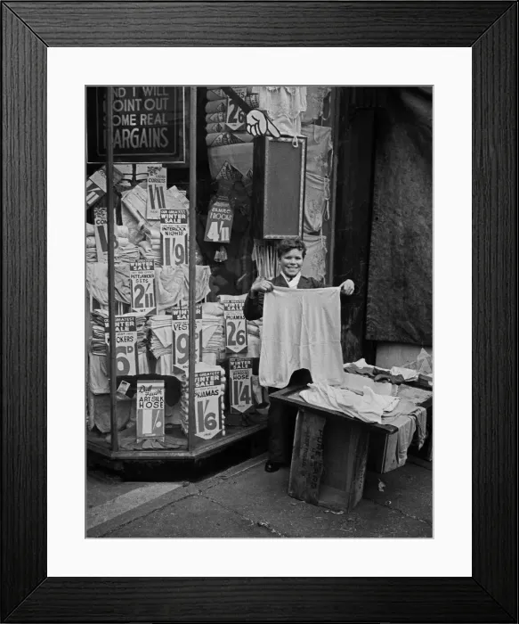 Framed Print : Shop assistant shows garments for inspection, London Framed Print : Shop assistant shows garments for inspection, London