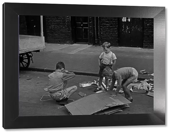 Three young boys playing in street, London