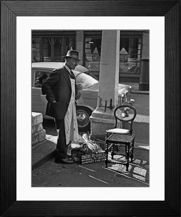 Framed Print : Tradesman repairs chairs in Central London street Framed Print : Tradesman repairs chairs in Central London street