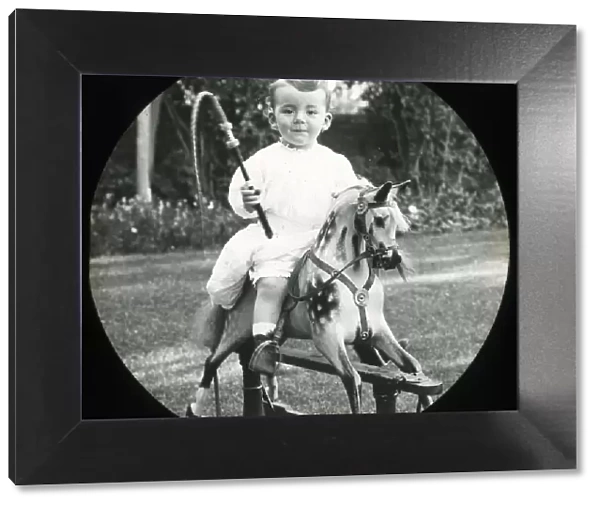 Little boy on a rocking horse with toy whip