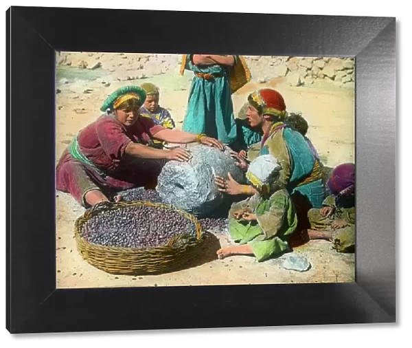 Persian women using a large grindstone, Iran