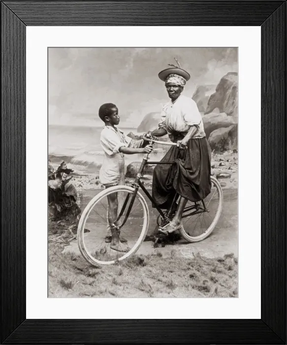Framed Print : c. 1900 West Indies - old woman on bicycle with a child Framed Print : c. 1900 West Indies - old woman on bicycle with a child