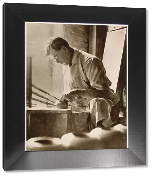A man forming articles upon the potters wheel: a thrower. Date: 1913