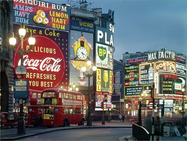 Piccadilly Circus by night, London. Date: 1960s