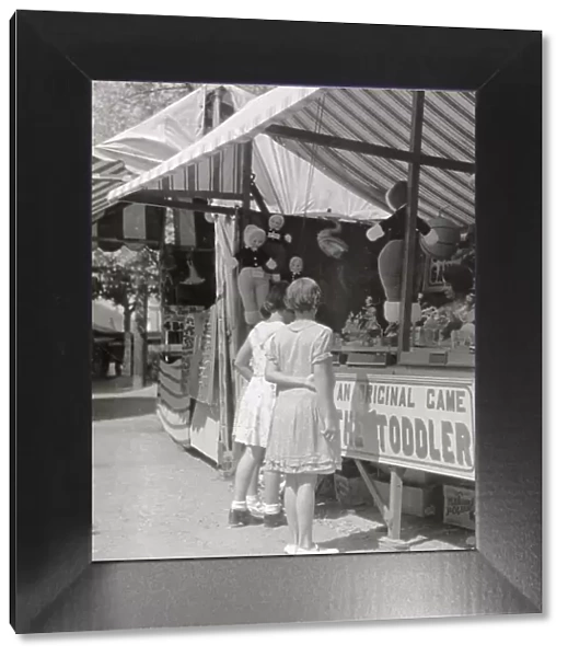 Girls looking at a stall at Looe fair, Cornwall Date: 1930s