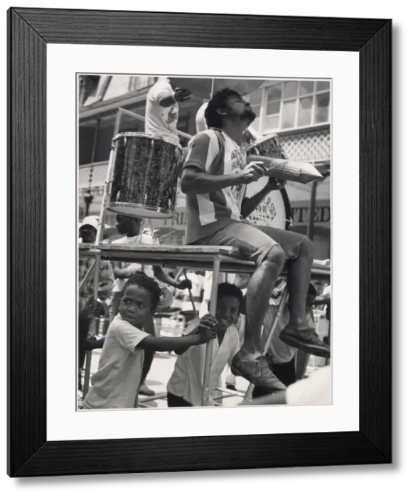 Framed Print : A musician sits on a float in an ecstatic trance, really into the music, while a couple of children sit beneath him at the Port of Spain Carnival, Trinidad, W. Indies. Date: 1968 Framed Print : A musician sits on a float in an ecstatic trance, really into the music, while a couple of children sit beneath him at the Port of Spain Carnival, Trinidad, W. Indies. Date: 1968