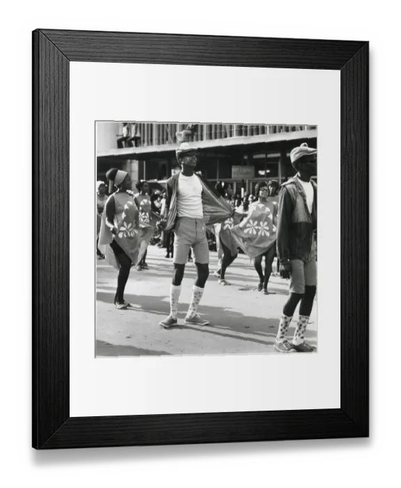 Framed Print : A man in shorts and long socks dances between two fashionable women at the Port of Spain Carnival, Trinidad, West Indies. Date: 1968 Framed Print : A man in shorts and long socks dances between two fashionable women at the Port of Spain Carnival, Trinidad, West Indies. Date: 1968