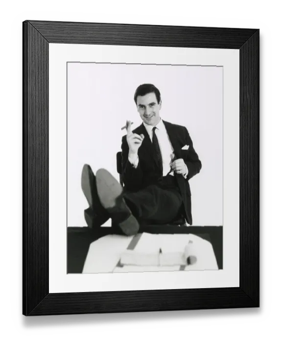 Framed Print : A man puts his feet up on his desk as he smokes a cigar. Date: late 1960s Framed Print : A man puts his feet up on his desk as he smokes a cigar. Date: late 1960s