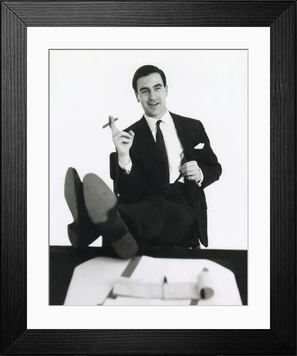 Framed Print : A banker puts his feet up on his desk and smokes a cigar. Date: late 1960s Framed Print : A banker puts his feet up on his desk and smokes a cigar. Date: late 1960s