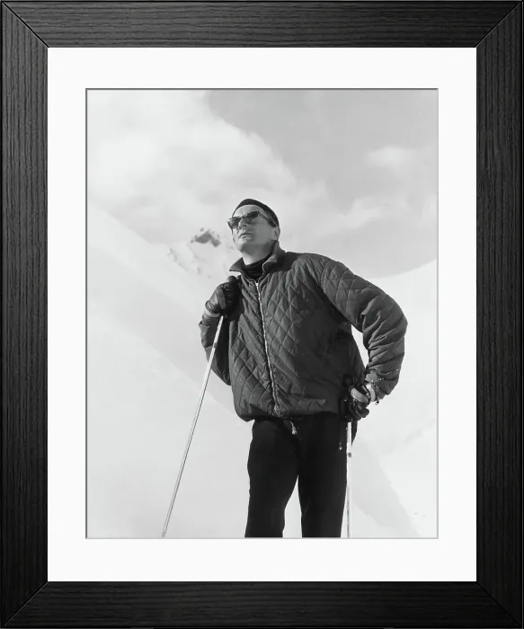 Framed Print : A male skier wearing a quilted jacket poses on the slopes. Date: late 1960s Framed Print : A male skier wearing a quilted jacket poses on the slopes. Date: late 1960s