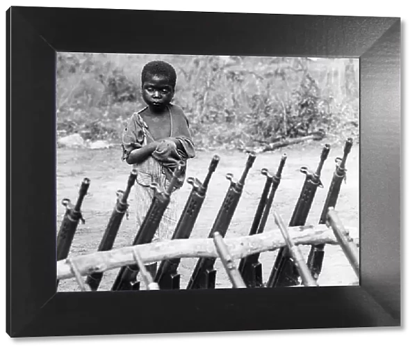 African orphan behind weapons