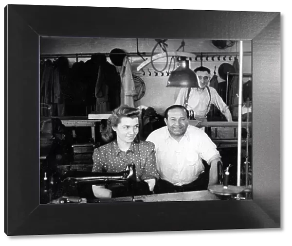 Three people in a tailors workshop