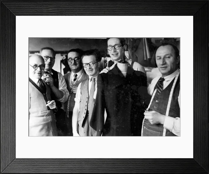 Framed Print : Tailors in a workshop with coat on display Framed Print : Tailors in a workshop with coat on display