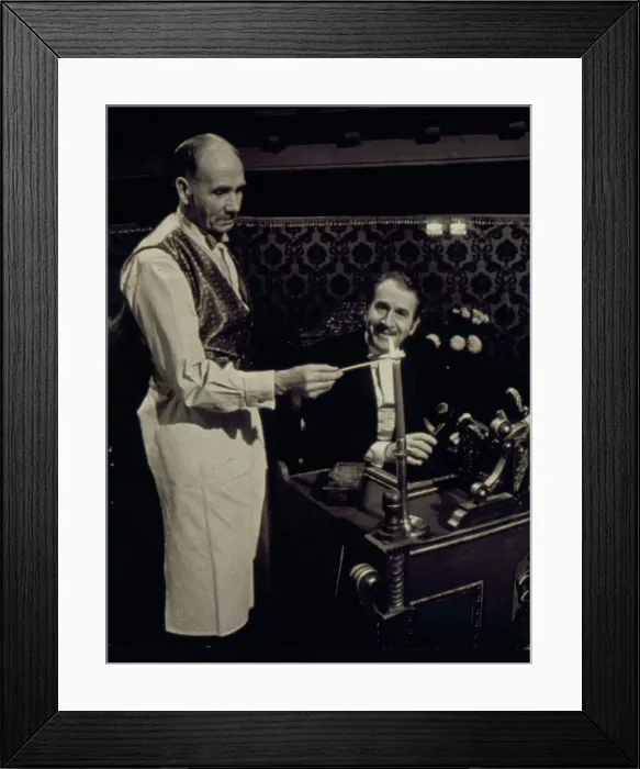 Framed Print : Two of the cast of the Old Time Music Hall TV show, known as The Good Old Days, filmed at the City Varieties in Leeds. The man on the left lights a candle, while the compere, played by the actor Leonard Sachs, smiles benignly. Date: 1960s Framed Print : Two of the cast of the Old Time Music Hall TV show, known as The Good Old Days, filmed at the City Varieties in Leeds. The man on the left lights a candle, while the compere, played by the actor Leonard Sachs, smiles benignly. Date: 1960s