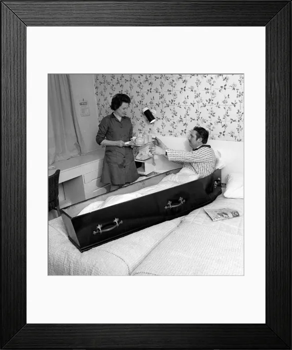 Framed Print : Eddie Merton, superstitious stuntman, who always slept in a coffin on the night before a dangerous stunt. Seen here sitting up in the coffin in his hotel bedroom for his morning cup of tea. Date: 1971 Framed Print : Eddie Merton, superstitious stuntman, who always slept in a coffin on the night before a dangerous stunt. Seen here sitting up in the coffin in his hotel bedroom for his morning cup of tea. Date: 1971