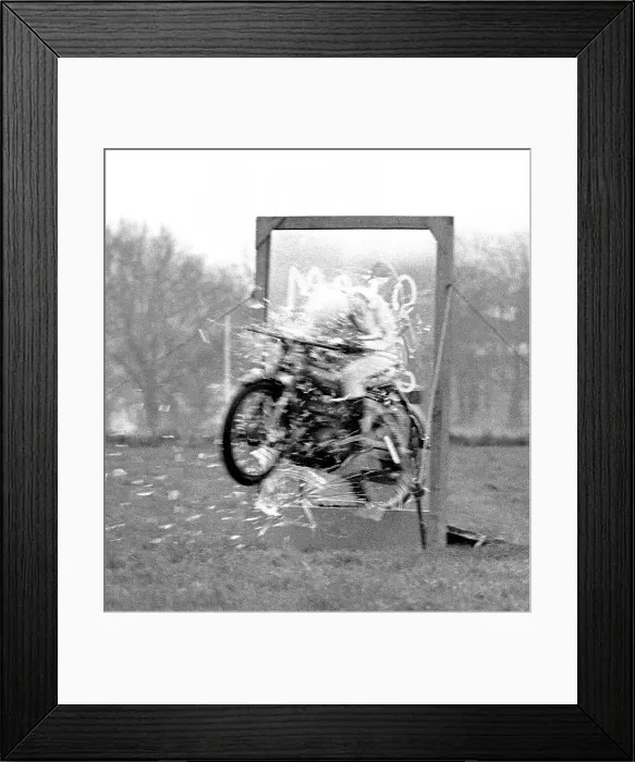 Framed Print : Stunt woman rides her motorbike through a glass plate, shattering it as she speeds through. Date: circa 1970s Framed Print : Stunt woman rides her motorbike through a glass plate, shattering it as she speeds through. Date: circa 1970s