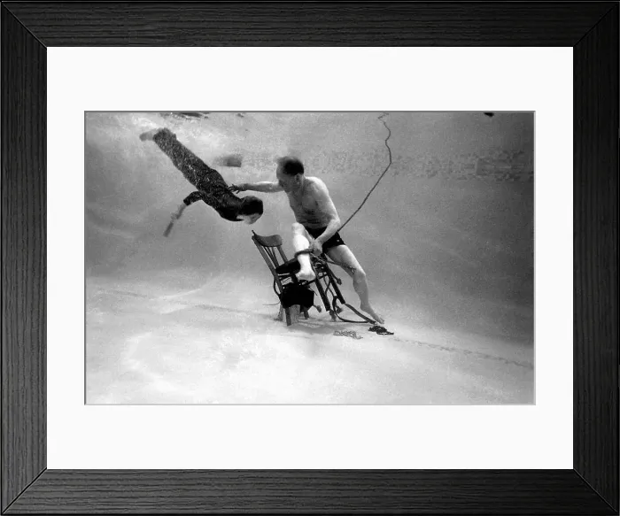 Framed Print : Underwater escapologist - a boy dives into a swimming pool to help a man untie himself from a chair. (1 of 3) Date: 1967 Framed Print : Underwater escapologist - a boy dives into a swimming pool to help a man untie himself from a chair. (1 of 3) Date: 1967