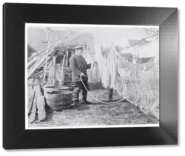A German fisherman mending his nets