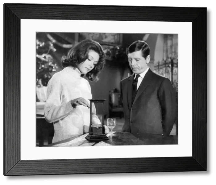 Framed Print : Emma Peel discussing a model guillotine with a protagonist Framed Print : Emma Peel discussing a model guillotine with a protagonist