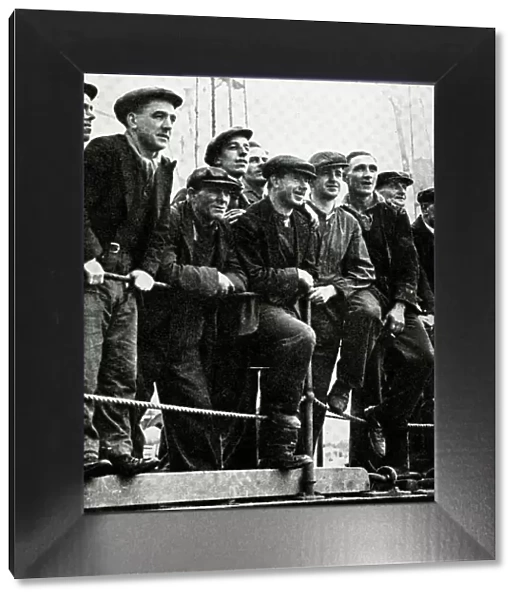 Workmen watch RMS Queen Mary on River Clyde