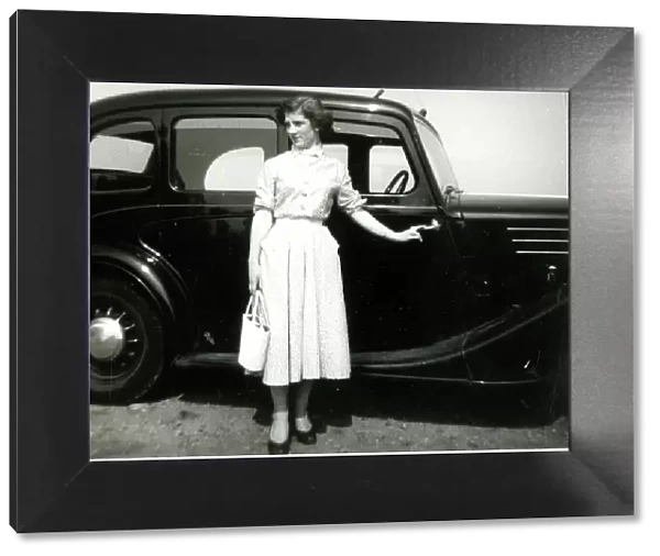 Young woman standing by a car