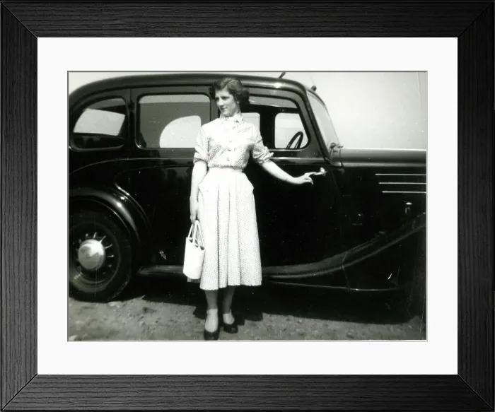 Framed Print : Young woman standing by a car Framed Print : Young woman standing by a car