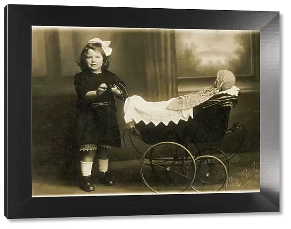 Young girl taking her dolly out in a fine perambulator