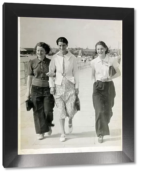 Three young ladies strolling along the seafront