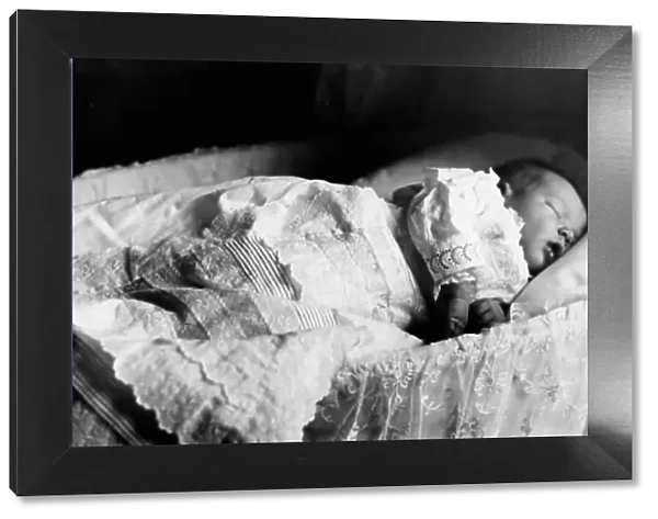 A two-week old baby in a cot, Victorian period