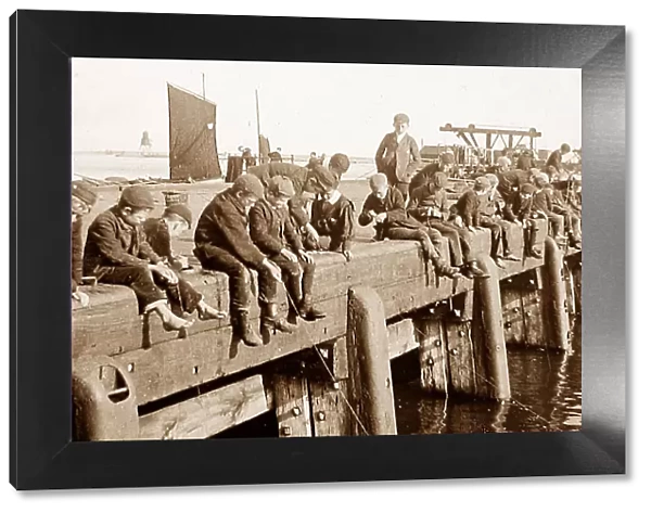 Boys fishing on a pier early 1900s