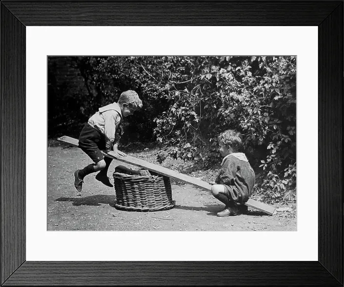 Framed Print : Children playing on a see-saw early 1900s Framed Print : Children playing on a see-saw early 1900s