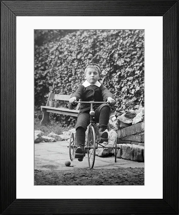 Framed Print : Boy playing on tricycle, early 1900s Framed Print : Boy playing on tricycle, early 1900s