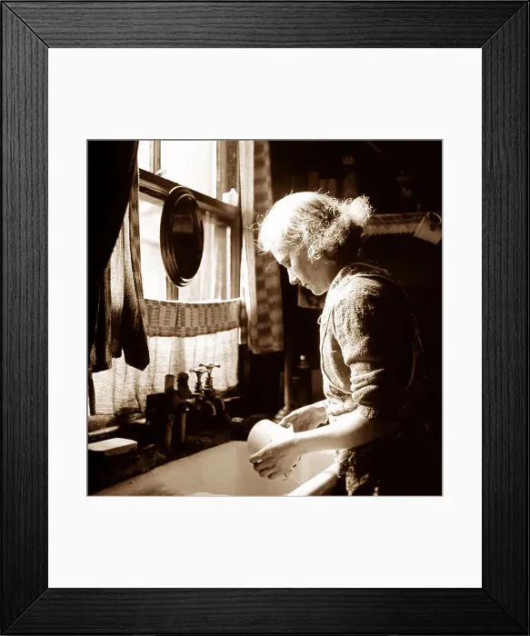 Framed Print : Woman at a kitchen sink, probably 1930s Framed Print : Woman at a kitchen sink, probably 1930s
