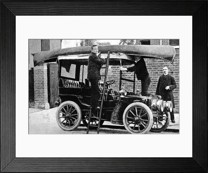 Framed Print : Fixing a canoe to the top of a veteran car, early 1900s Framed Print : Fixing a canoe to the top of a veteran car, early 1900s
