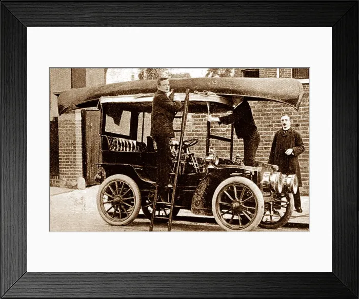 Framed Print : Fixing a canoe to the top of a veteran car, early 1900s Framed Print : Fixing a canoe to the top of a veteran car, early 1900s