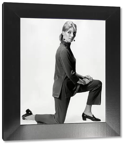 Model kneeling in dark co-ordinated trouser suit