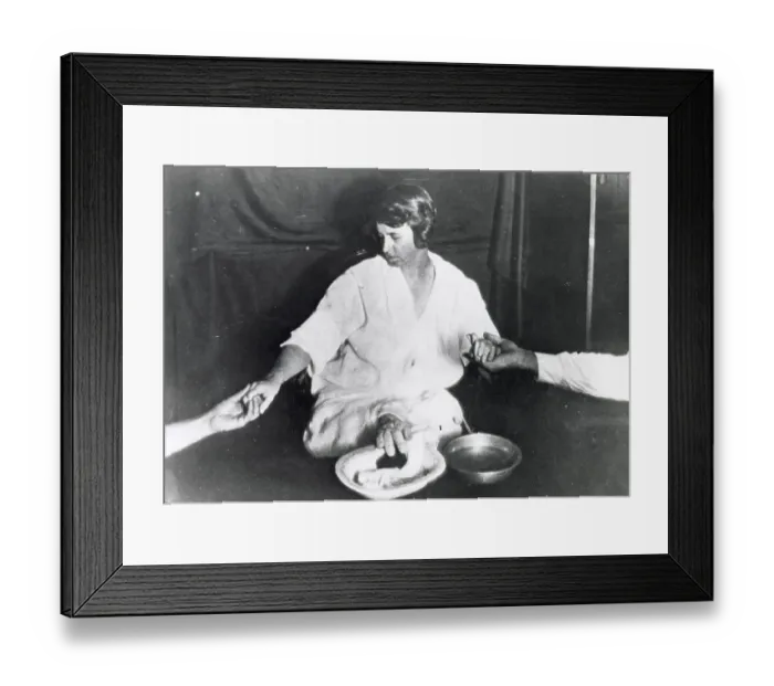 Framed Print : Margery, in trance and her wrists held by sitters, exudes ectoplasm forming a teleplasmic hand from somewhere between her legs Date: circa 1924 Framed Print : Margery, in trance and her wrists held by sitters, exudes ectoplasm forming a teleplasmic hand from somewhere between her legs Date: circa 1924